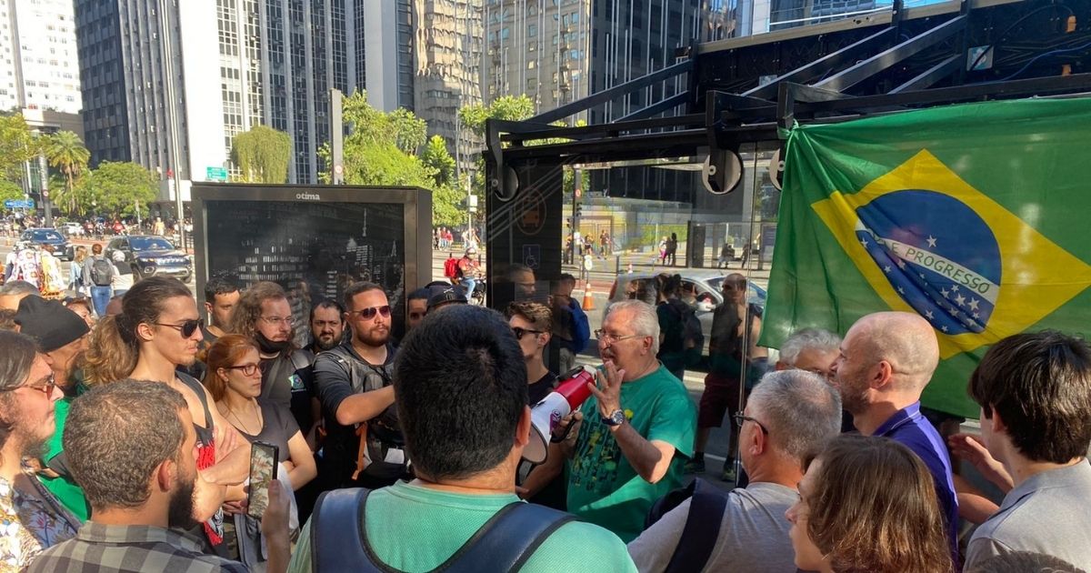imagem mostra o político Antonio Neto discursando com um megafone em meio aos participantes de um debate sobre soberania nacional na Avenida Paulista em São Paulo